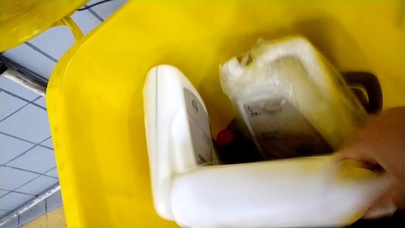 9月21日，维修技师将一桶尚未开封的变速箱油藏在垃圾桶里，这个”空桶“被做了标记，技师给其外面套了一个塑料袋。来源：新京报调查组