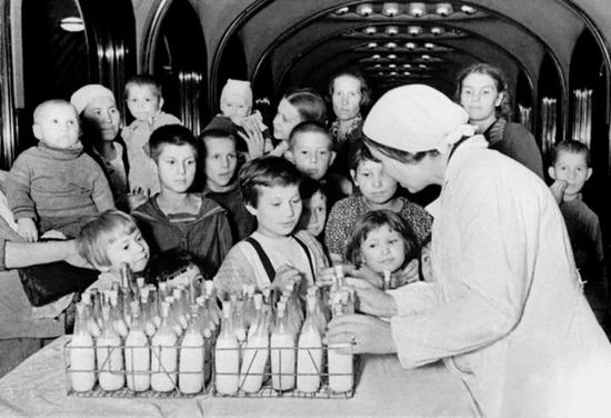 二战期间，在地铁中躲避空袭的莫斯科儿童，准备领取牛奶